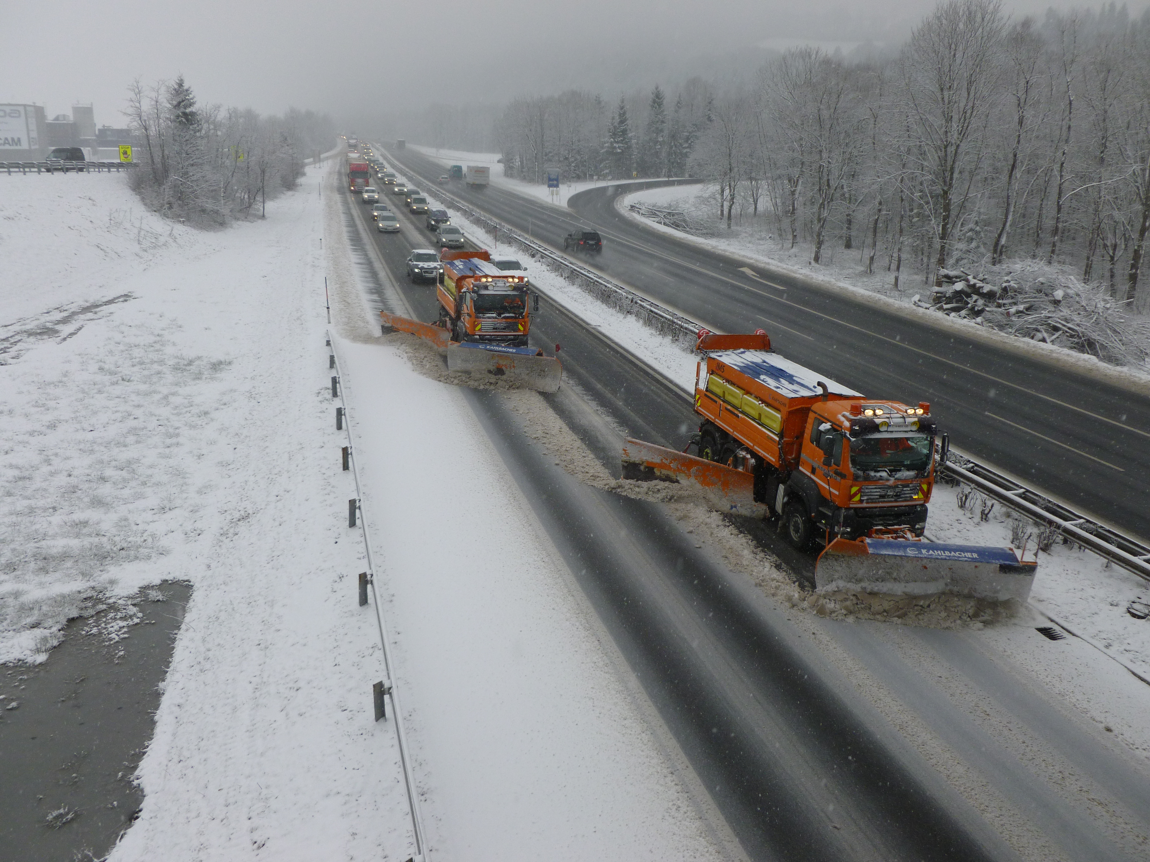 Schneepflüge fahren über die Autobahn