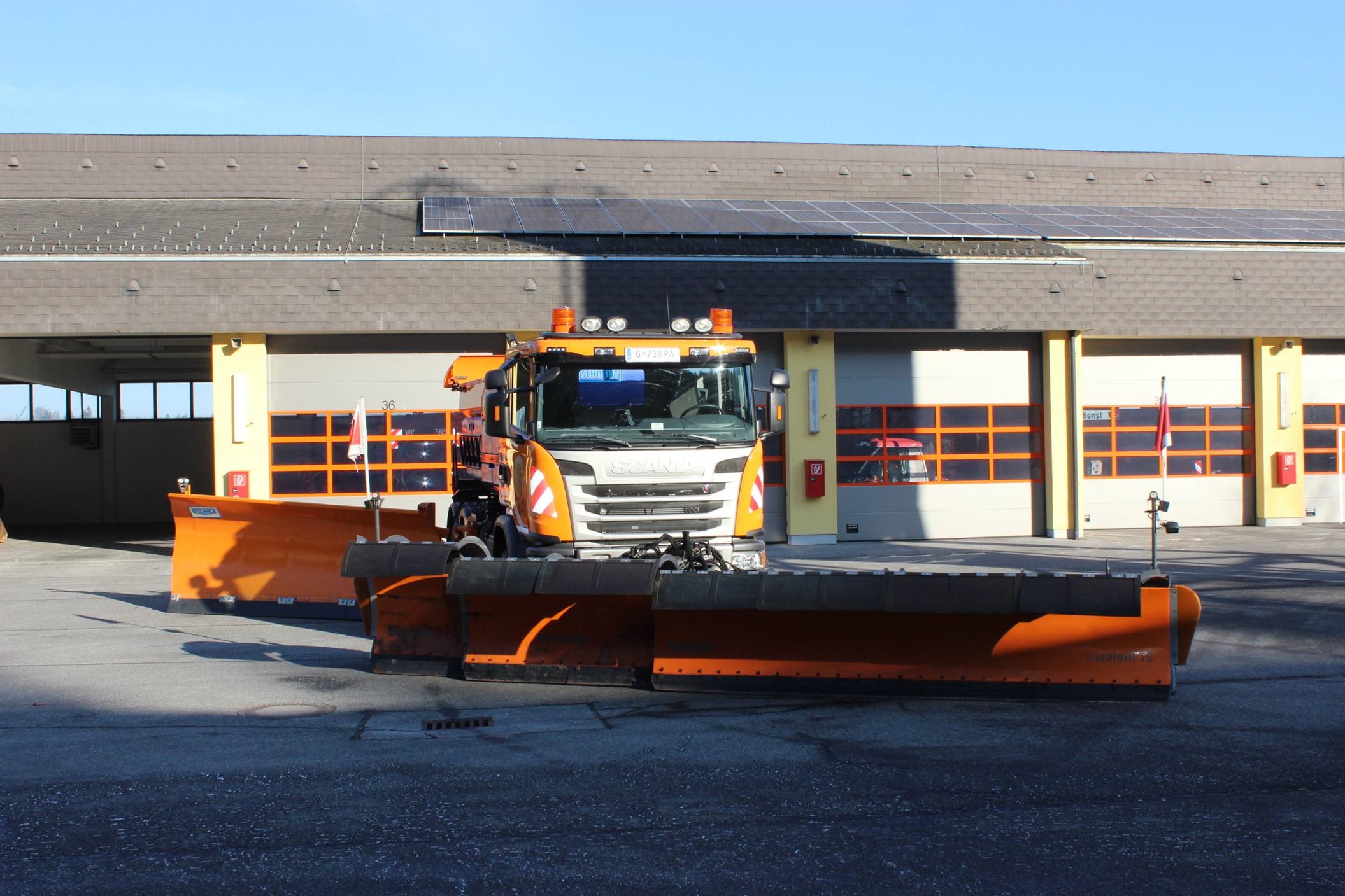 Schneepflug am Hof einer Autobahnmeisterei, der seine Schaufel seitlich ausfahren kann. 