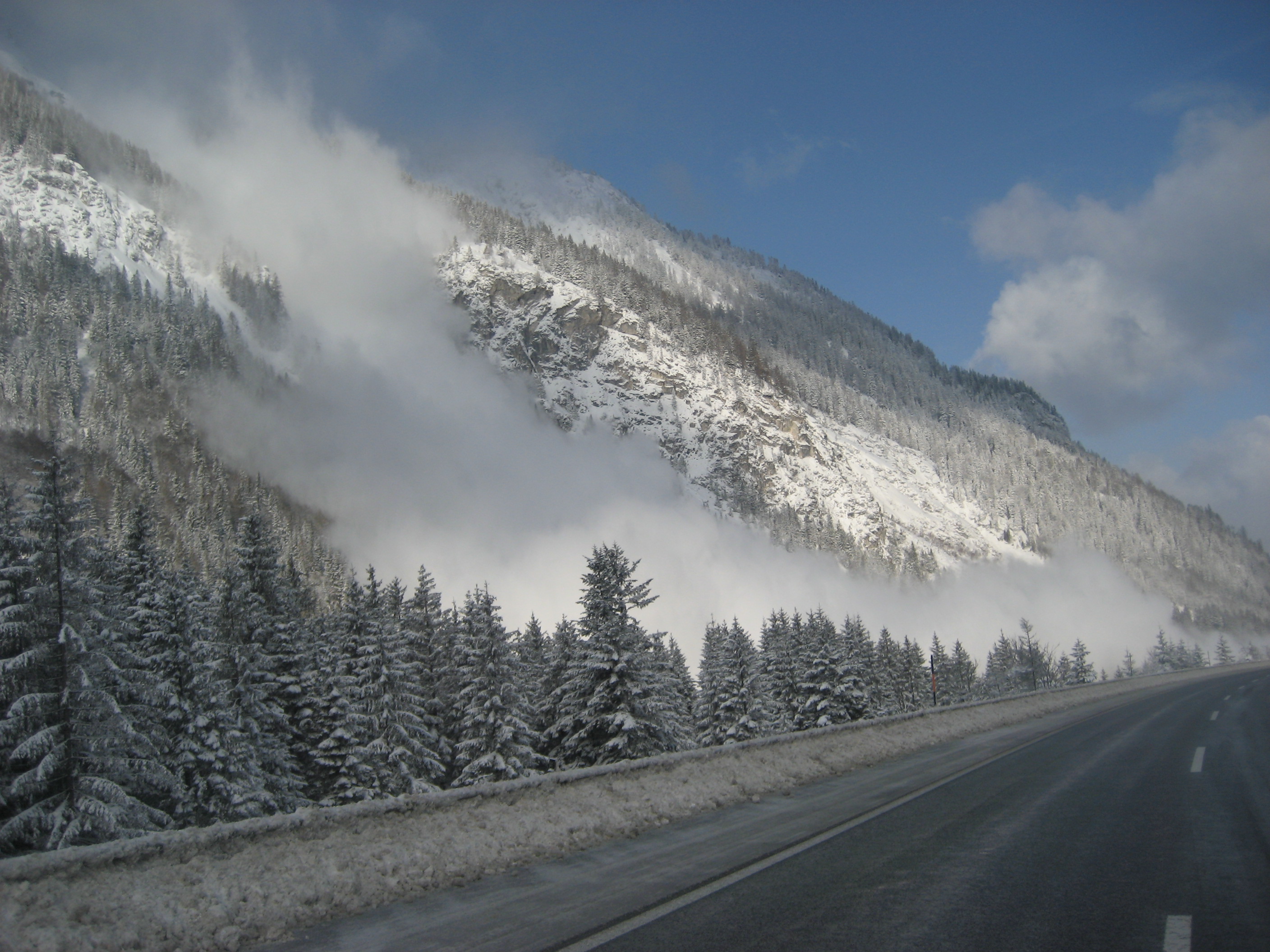 Eine Lawine rauscht einen verschneiten Abhang hinunter