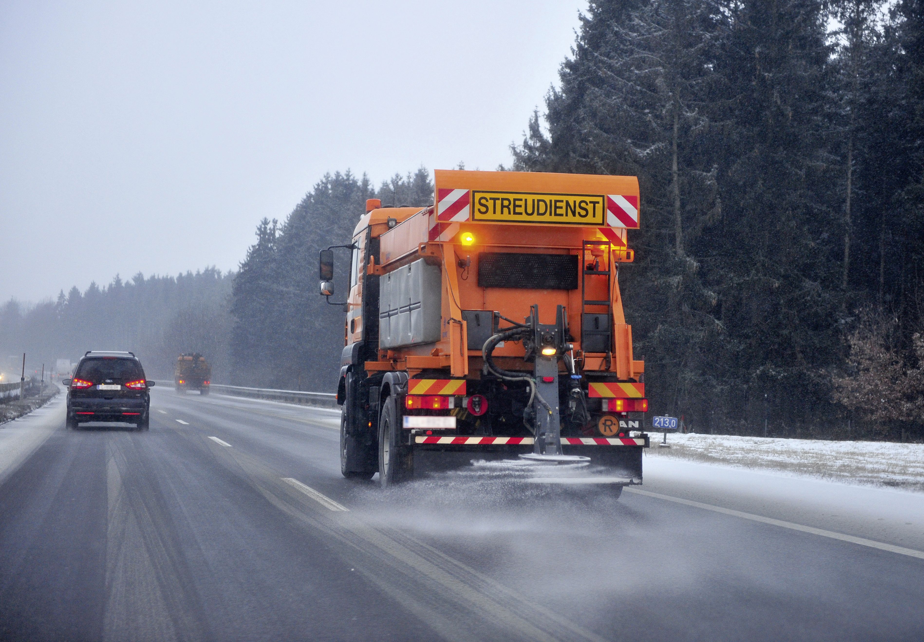 Winterdienstfahrzeug streut Salz auf die Autobahn