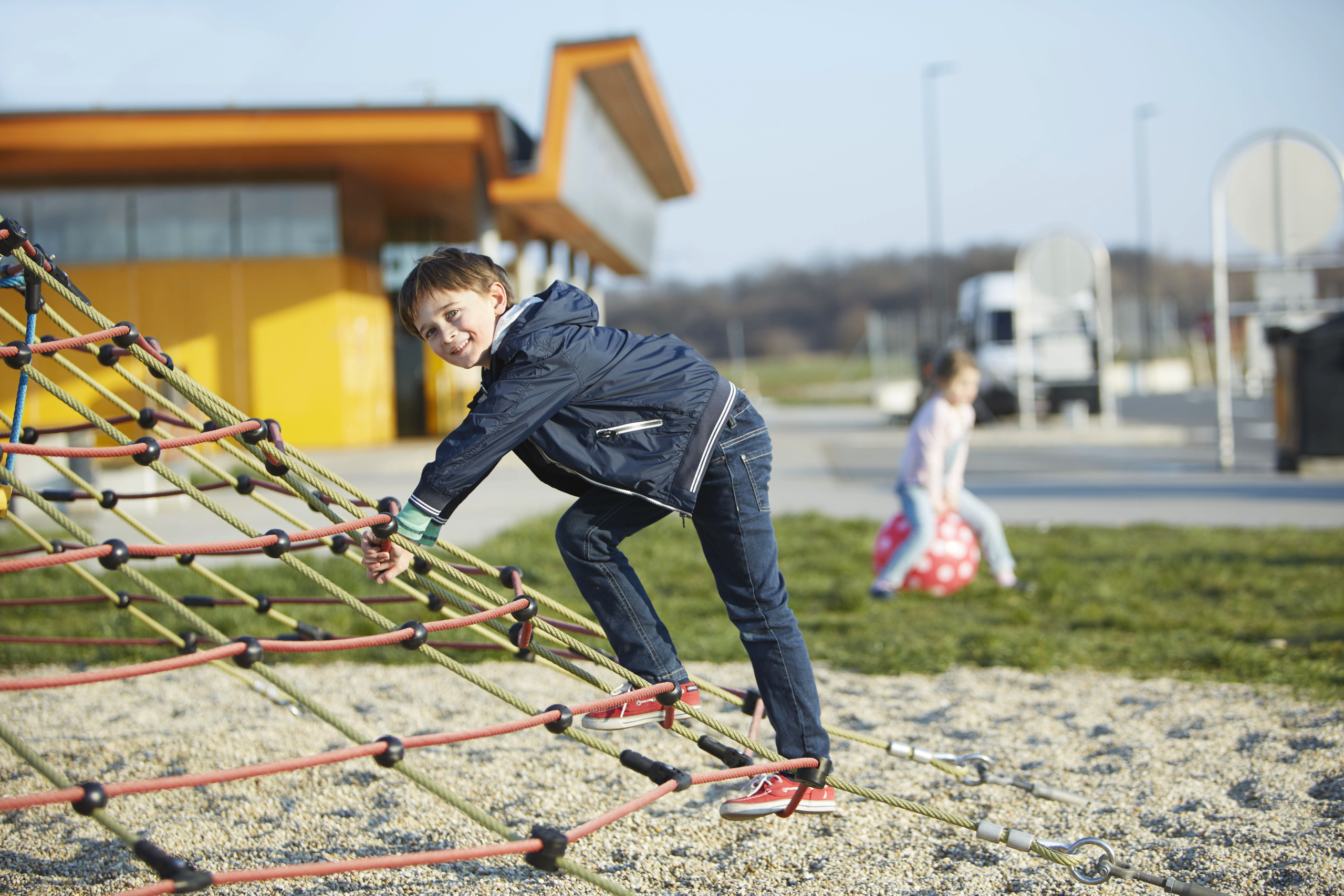 Ein Kind klettert auf einem Netz auf einem ASFINAG Rastplatz Kinderspielplatz