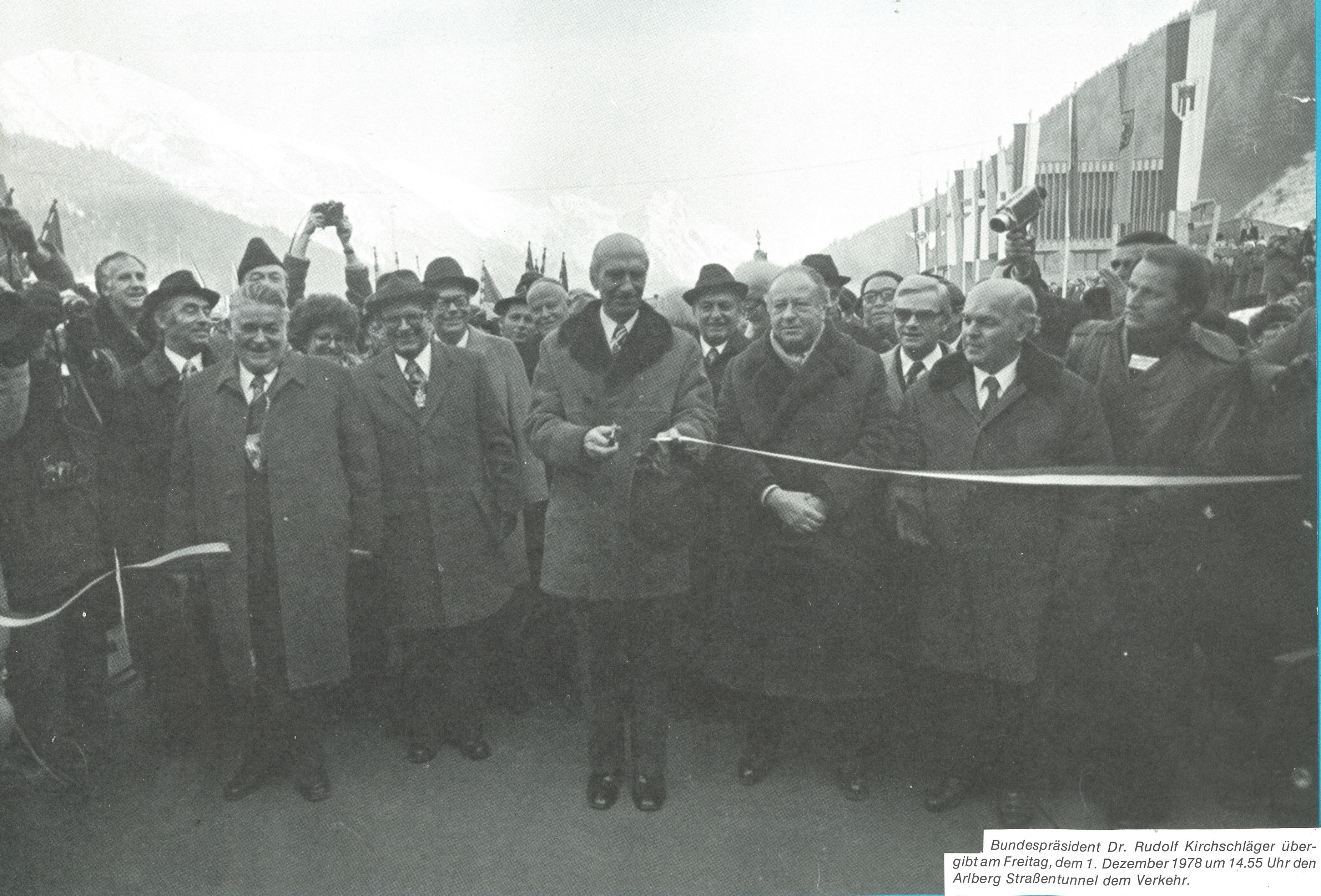 Ein Mann hat soeben ein Band durchgeschnitten. Hinter ihm steht eine aufgeregte Menschenmenge-