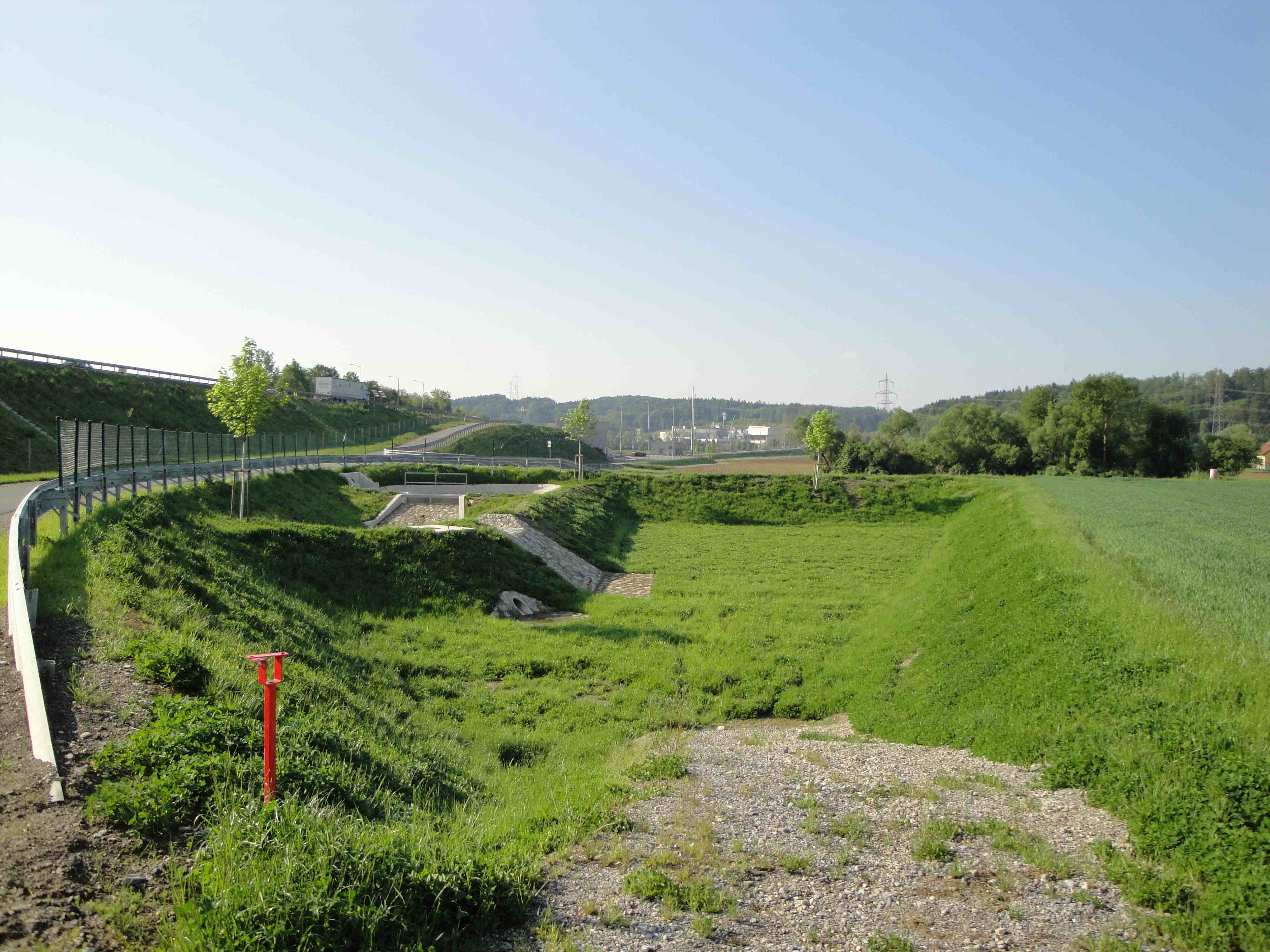 Eine Gewässerschutzanlage, die schon mit Wiese überwachsen ist. Man sieht sie kaum.