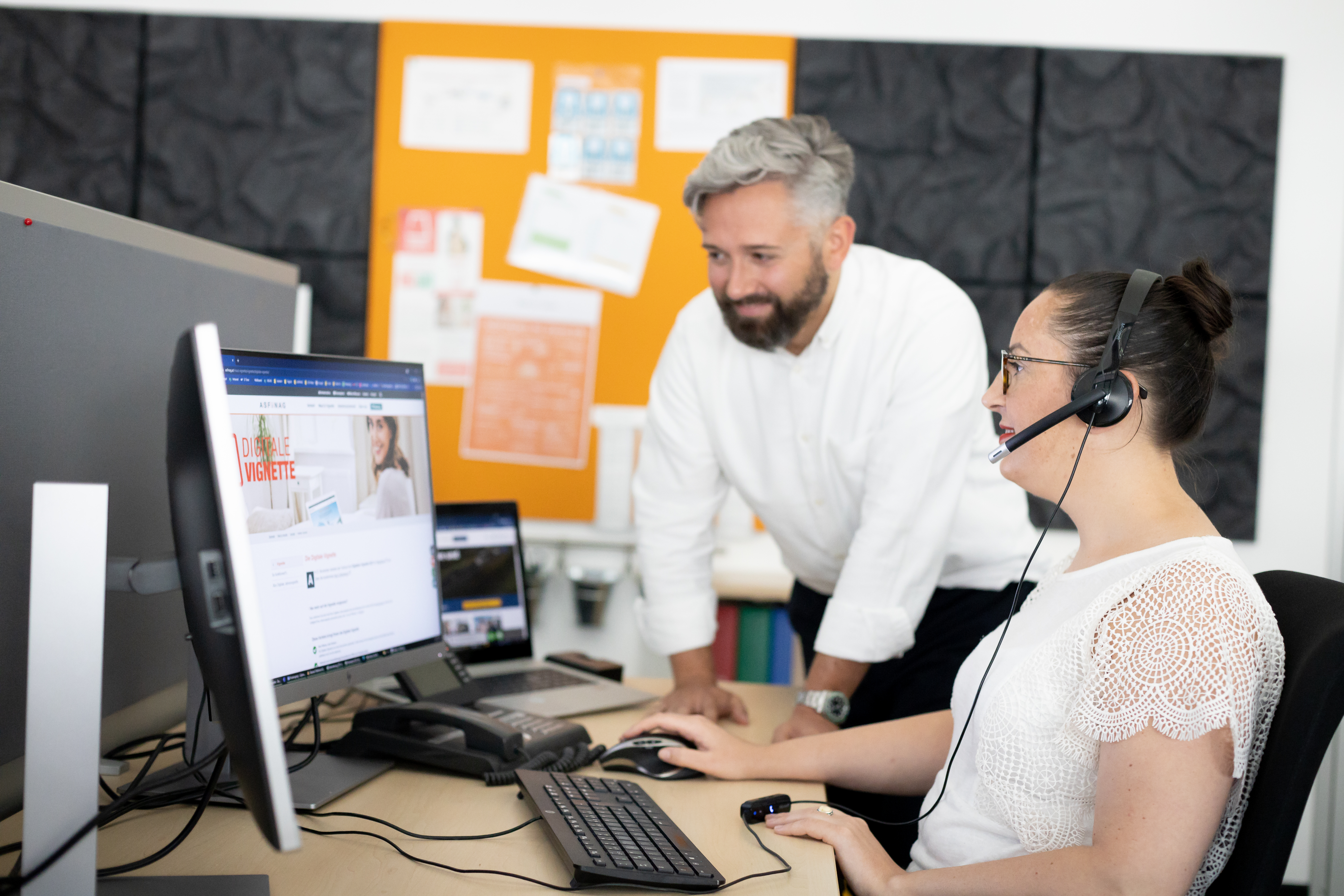 Zwei Mitarbeitende des ASFINAG Service Center schauen in den Computer