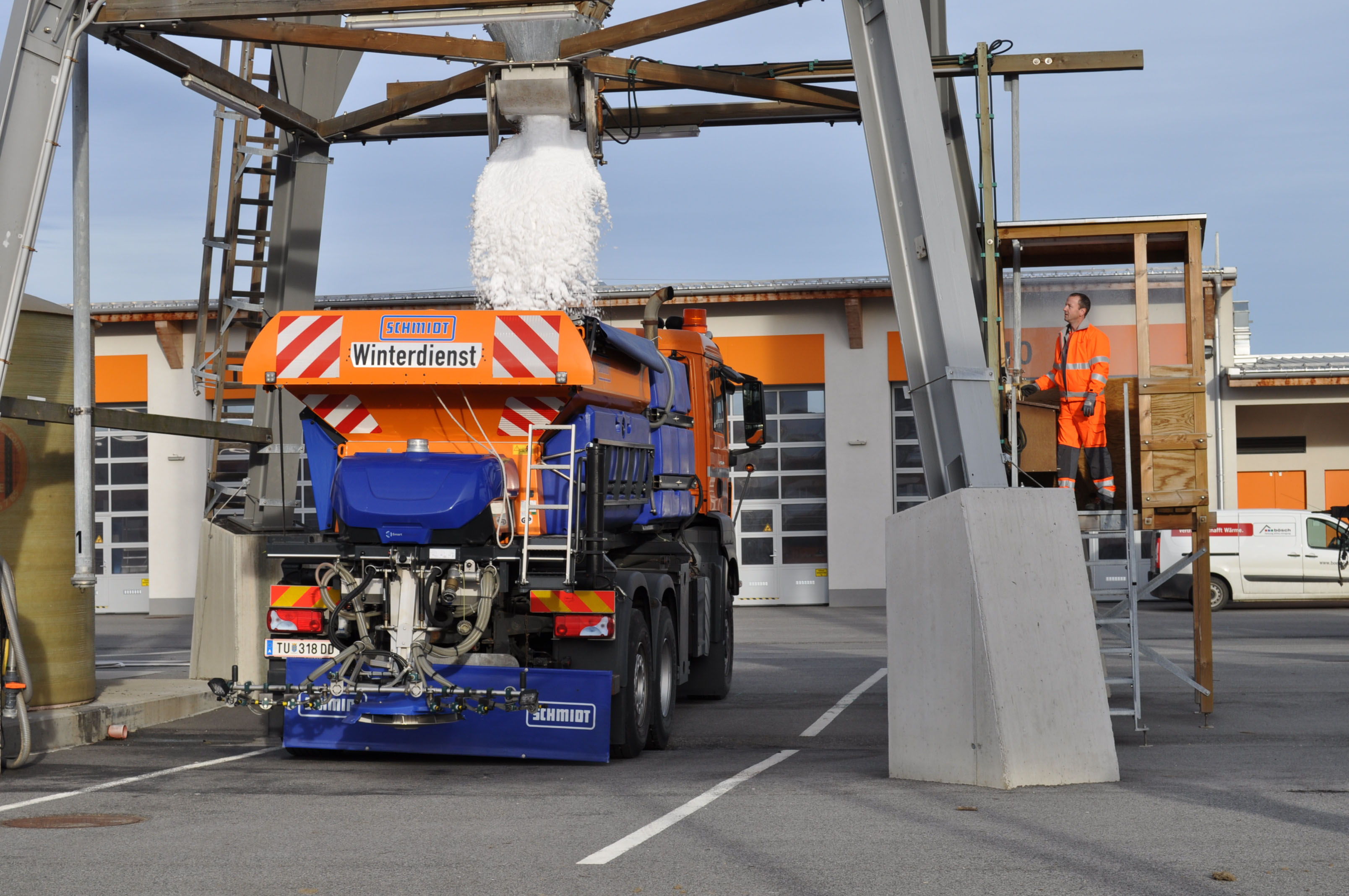 Kombi-Streufahrzeug, dessen Tank gerade in der Autobahnmeisterei mit Salz gefüllt wird.