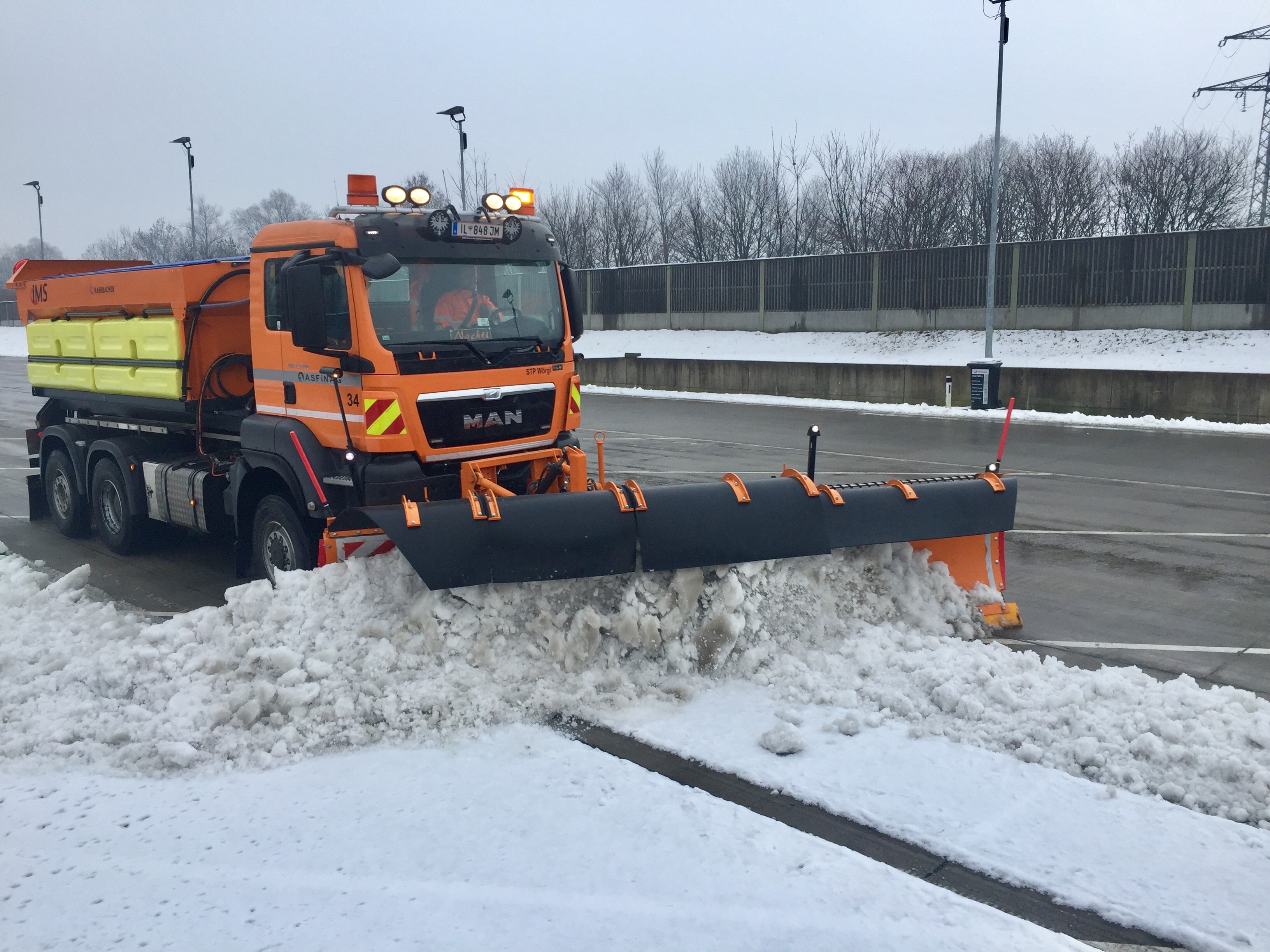 Schneepflug räumt Parkplatz